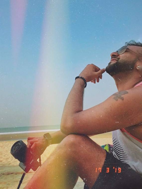 Asif on a beach holding a camera